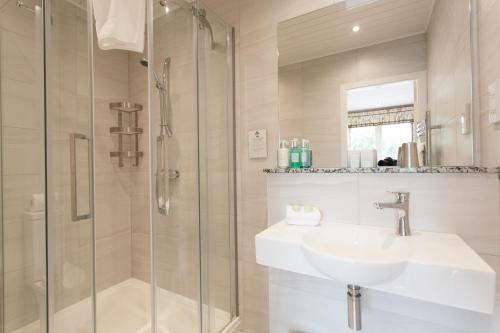 
a bathroom with a shower, sink, and tub at Kilcamb Lodge Hotel in Strontian
