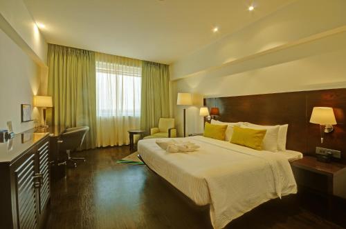 een hotelkamer met een groot bed en een bureau bij Regenta Central Hestia Dahej, Bhensali in Dahej