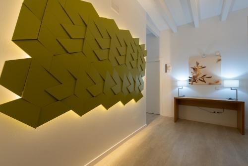 a room with a large green wall art on the wall at Soller Plaza in Sóller