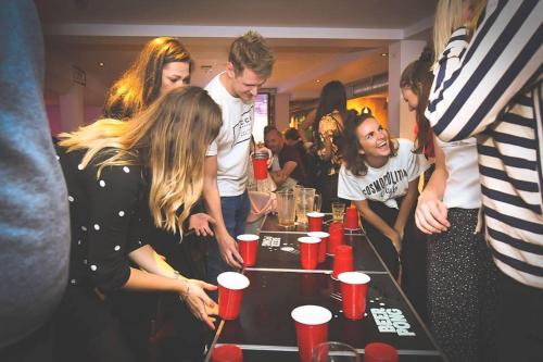 a group of people standing around a table with cups on it at St Christopher's Inn Oasis - London Bridge - Female Only in London