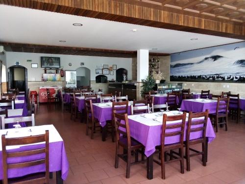 Un comedor con mesas y sillas moradas. en Canadian Star, en Praia de Mira