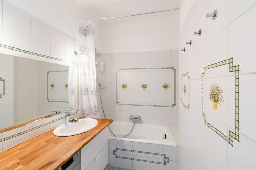 un bagno bianco con lavandino e vasca di TÉO SUD Les balcons du nouveau Marseille, Lumineux, spacieux et bien équipé a Marsiglia