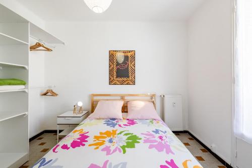 une chambre avec un lit avec un couvre-lit fleuri dans l'établissement TÉO SUD Les balcons du nouveau Marseille, Lumineux, spacieux et bien équipé, à Marseille