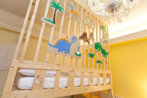 a nursery with a wooden crib with dinosaur decals at 歐拉民宿 l 大空間包棟 l 親子溜滑梯 l 專業音響 in Taitung City