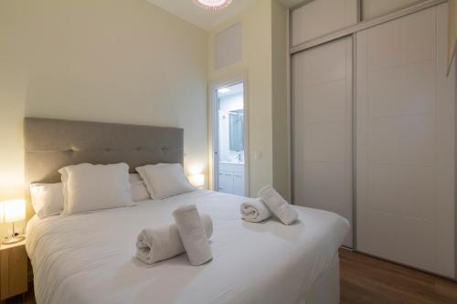 a bedroom with a white bed with towels on it at Apartamento TEMPORAL Diseño Chueca-Malasaña BRC40 in Madrid
