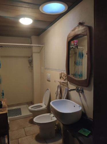 a bathroom with a sink and a toilet and a mirror at La Corte di Nonna Quercia in Cagli