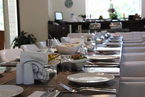a long table with white plates and silverware on it at Lavender Boutique Hotel in Ramallah