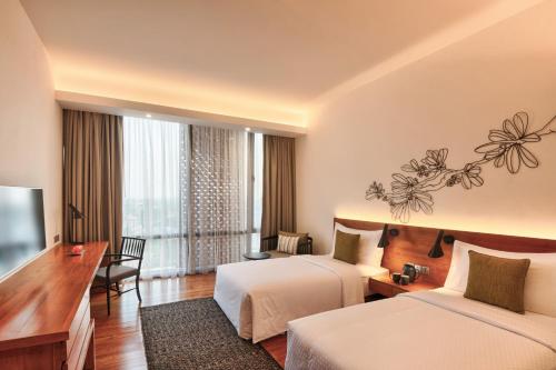 a hotel room with two beds and a television at Jetwing Colombo Seven in Colombo