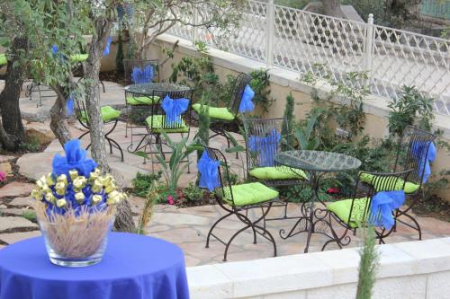 a group of chairs and tables with a vase of flowers at Lavender Boutique Hotel in Ramallah