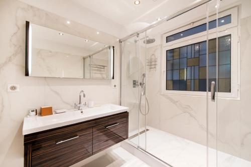 une salle de bain avec un lavabo et une douche dans l'établissement Luxury Montaigne apartment, à Paris