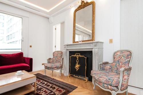 un salon avec une cheminée et un miroir dans l'établissement Luxury Montaigne apartment, à Paris