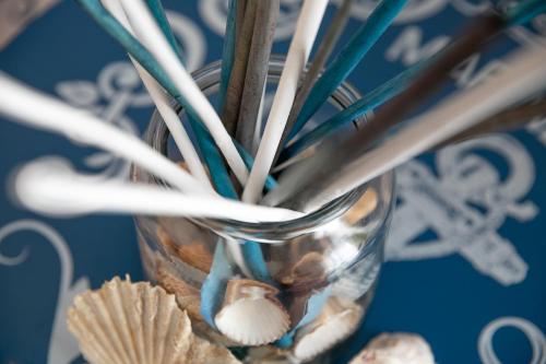 a glass vase filled with toothpicks and shells at Ciriga Sicily Glamping in Santa Maria Del Focallo