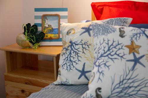 a bed with blue and white pillows and a table with a mirror at Ciriga Sicily Glamping in Santa Maria Del Focallo