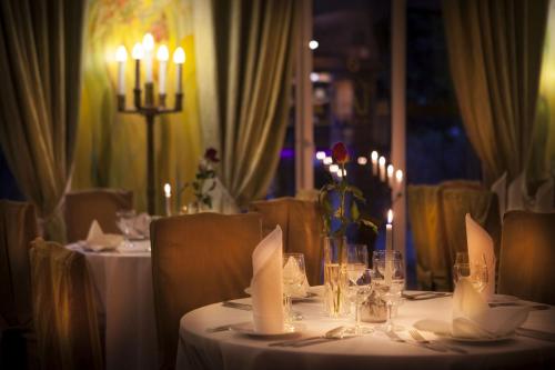 a table with white table cloths and candles on it at Hotel Las Piechowice in Szklarska Poręba