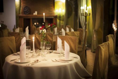 a table with a white table cloth and candles on it at Hotel Las Piechowice in Szklarska Poręba