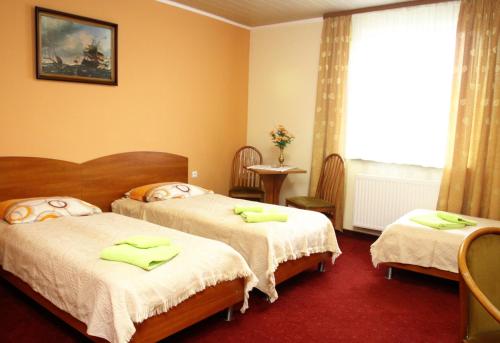 Park Hotel في رزيبين: غرفة نوم بسريرين عليها مناشف خضراء