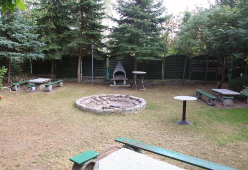 a park with picnic tables and a fire pit at Park Hotel in Rzepin