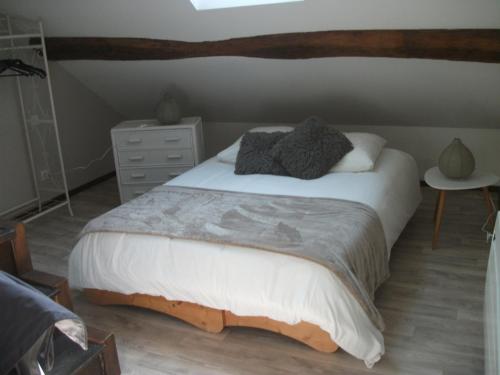 a bedroom with a large bed and a dresser at L'Inattendue in Chaumont