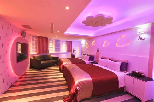 a bedroom with two beds and a purple ceiling at Yosemite Motel - Taiyuan Branch in Taichung