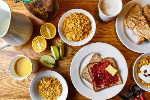 ロンドンにあるSt Christopher's Inn London Bridge - Oasis Female Onlyの朝食の食べ物とコーヒーの皿が置かれたテーブル