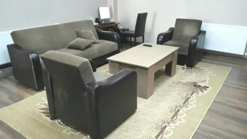 a living room with chairs and a couch and a table at Apartment Gorgiladze 66 in Batumi