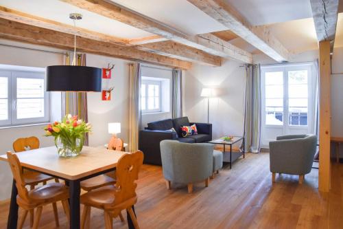 un soggiorno con tavolo, sedie e divano di Spitzing Lodge Ferienwohnungen - Wanderparadies in den Bergen a Spitzingsee