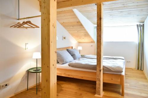 a bedroom with a wooden bed in a room at Spitzing Lodge Ferienwohnungen - Wanderparadies in den Bergen in Spitzingsee