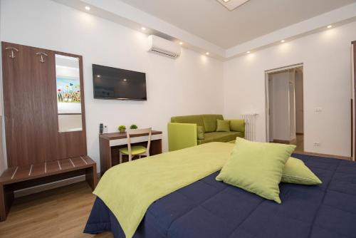 a bedroom with a bed and a desk and a television at Colosseo Apartments and Rooms - Rome City Centre in Rome