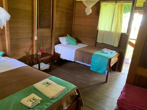 1 dormitorio con 2 camas de color verde y marrón en Estancia Bello Horizonte en Puerto Maldonado