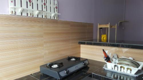 a stove in a kitchen with a counter top at Cottage Muslim Homestay ByWawaSha in Tanjung Malim