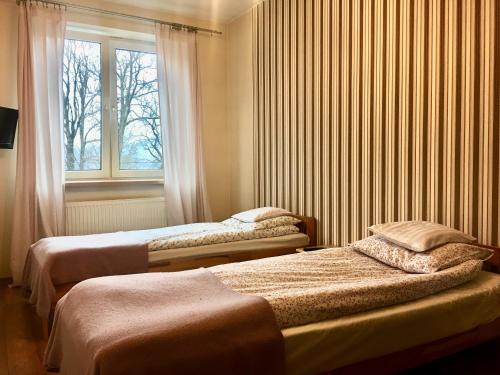 two beds in a room with a window at Apartamenty Skaldowie in Zakopane