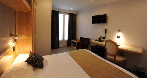 a hotel room with a bed and a desk at Hôtel Du Midi Paris Montparnasse in Paris