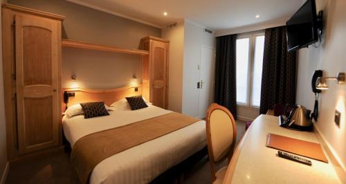 a hotel room with two beds and a television at Hôtel Du Midi Paris Montparnasse in Paris
