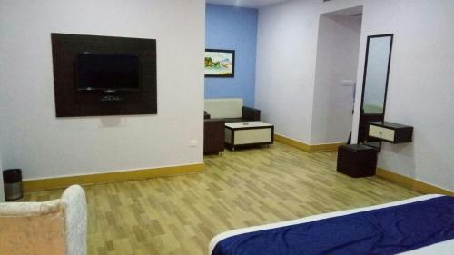 a room with a tv on a wall at The Kannelite in Jamshedpur