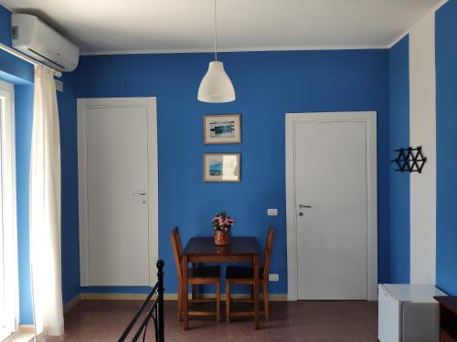 a dining room with blue walls and a table at B&B De Angelis in Ginosa Marina