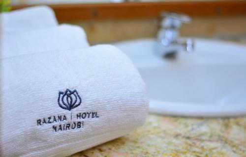 a white towel on a sink in a bathroom at Razana Hotel in Nairobi