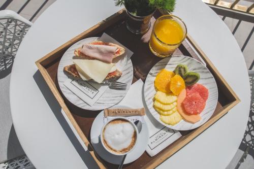 a tray with two plates of food and a cup of coffee at Hotel Almirante in Alicante
