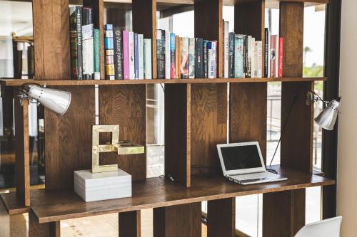 a book shelf with a laptop computer on it at Hotel Almirante in Alicante