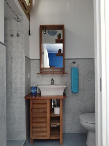a bathroom with a sink and a mirror and a toilet at B&B De Angelis in Ginosa Marina