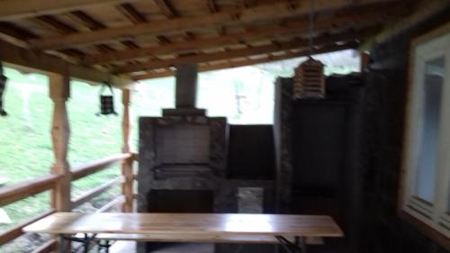 einen Holztisch auf einer Veranda mit einem Holzofen in der Unterkunft La cretu in Rozavlea