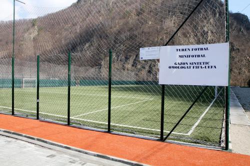 a tennis court with a sign on a fence at Hotel Class in Brezoi