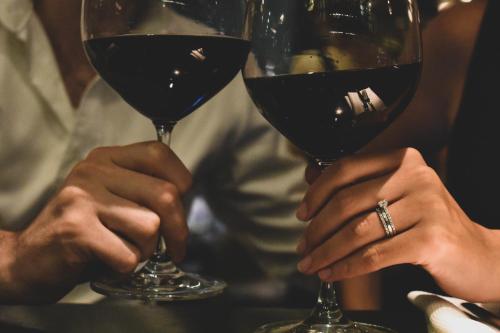 two people holding two glasses of red wine at The Rothschild Hotel - Tel Aviv's Finest in Tel Aviv