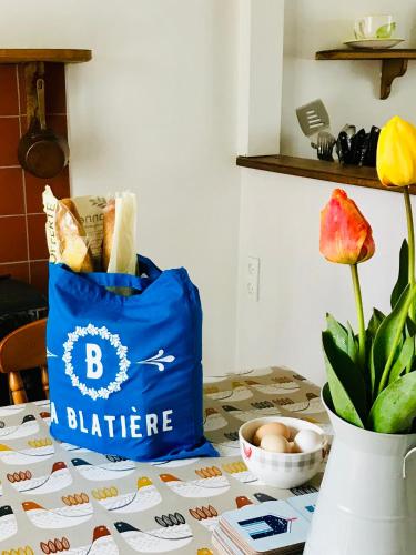 a blue bag sitting on a table with a vase at La Blatière French Cottages in La Chapelle-Saint-Étienne