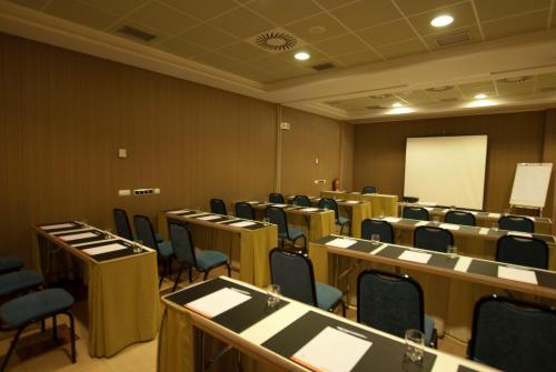 a conference room with tables and chairs and a whiteboard at Hotel Andia in Orcoyen