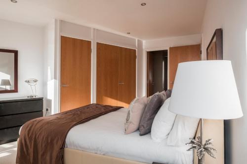 a bedroom with a large bed with a lamp at The Chambers, Riverside West in Leeds