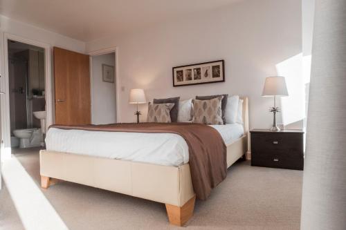 a bedroom with a large bed and a bathroom at The Chambers, Riverside West in Leeds