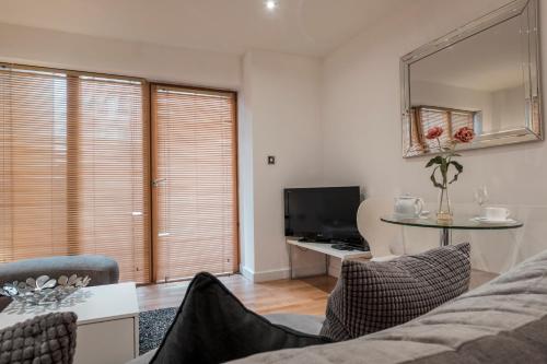 a living room with a couch and a table and a television at The Chambers, Riverside West in Leeds