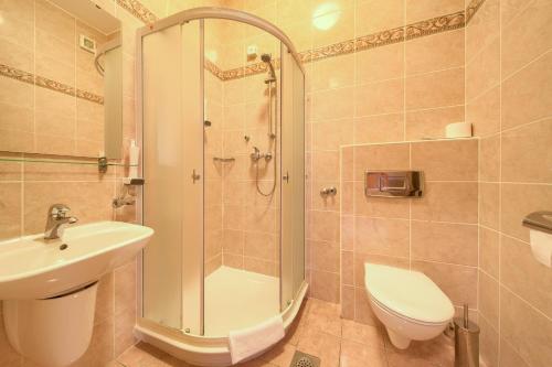 a bathroom with a shower, toilet and sink at Villa Tamaris - Hotel Resort Dražica in Krk