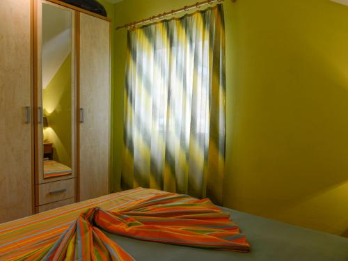 a bedroom with a bed with a curtain and a mirror at Kamenari Laura in Kamenari