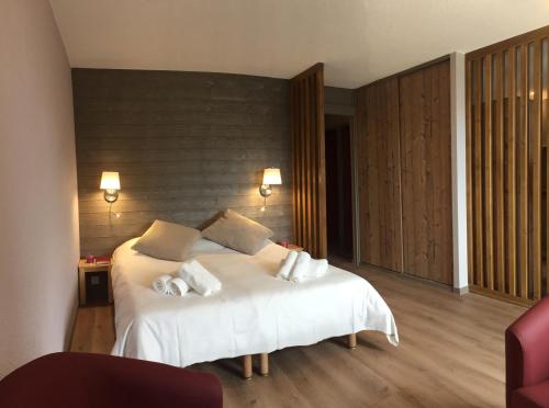 a bedroom with a bed with white sheets and pillows at Village Vacances Le Tarbesou in Ax-les-Thermes